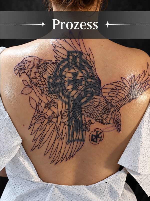Zwischenstand während des Cover-Up-Prozesses mit großflächigem Rabenentwurf über dem bestehenden Tattoo. Die neue Komposition zeigt, wie das alte Motiv in die Gestaltung integriert wird.