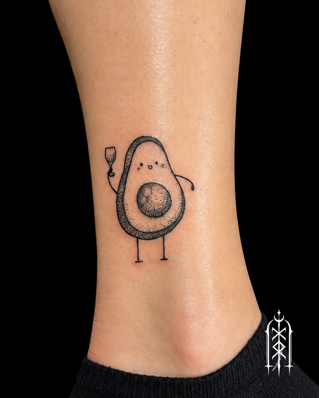 Kleines illustratives Avocado-Tattoo mit Weinglas am Knöchel in Fulda